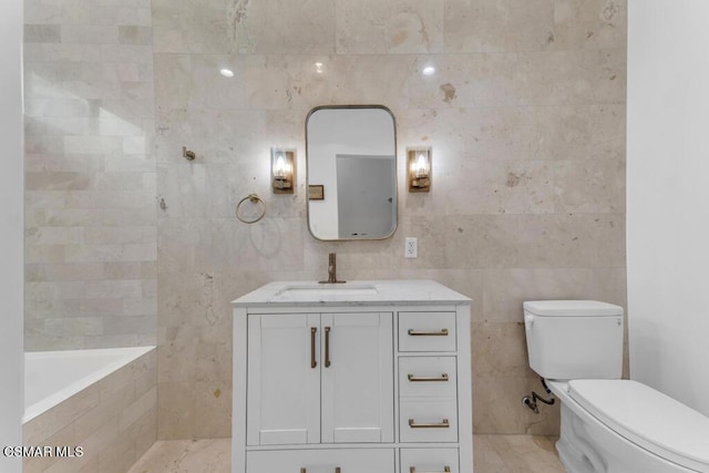 bathroom featuring tile walls, vanity, a relaxing tiled tub, and toilet