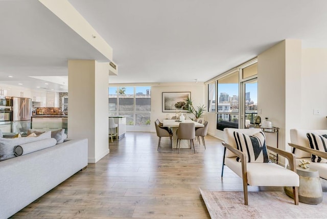 dining room with light hardwood / wood-style floors and a wall of windows