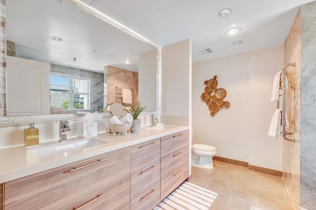 bathroom with toilet, tile patterned floors, and vanity