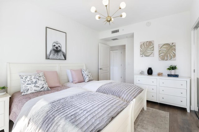 bedroom with dark wood-type flooring and a chandelier