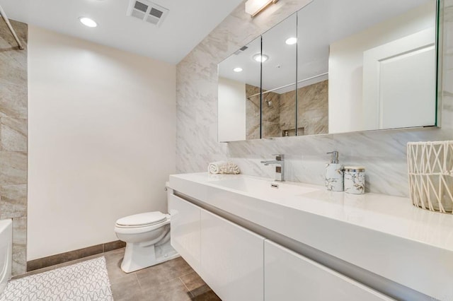 bathroom with tile patterned flooring, vanity, tasteful backsplash, toilet, and walk in shower