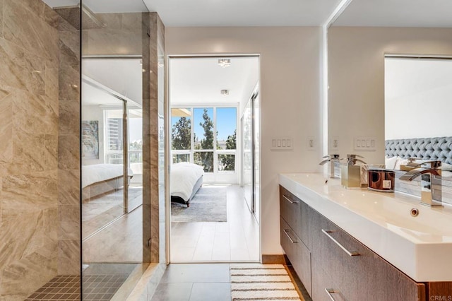 bathroom with an enclosed shower, vanity, and tile patterned flooring