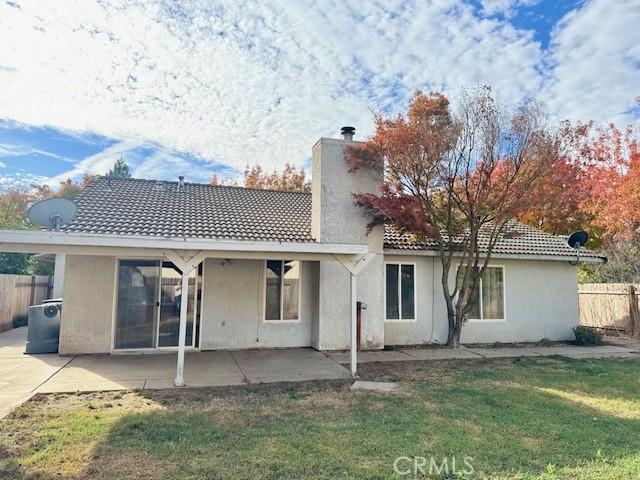 rear view of property featuring a yard and a patio