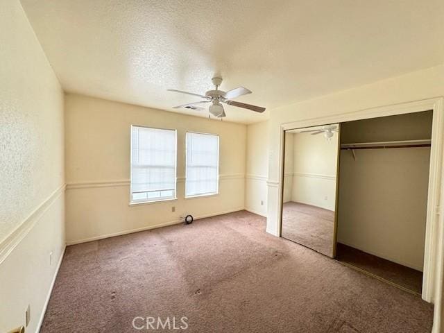 unfurnished bedroom with carpet flooring, a textured ceiling, a closet, and ceiling fan