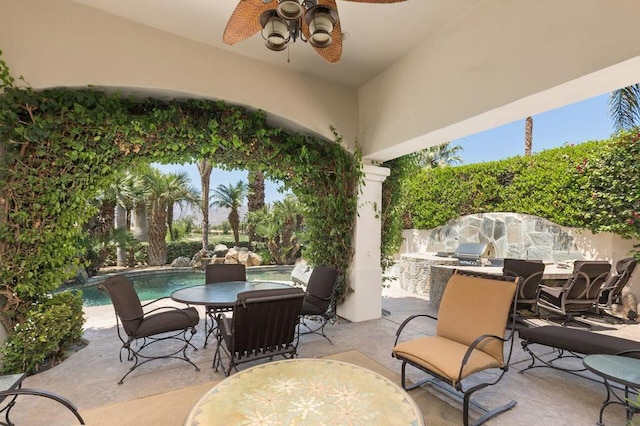 view of patio with ceiling fan, a fenced in pool, and exterior kitchen