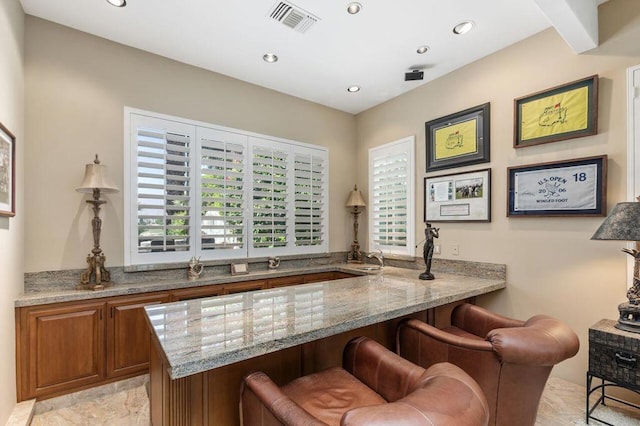 bar with light stone counters and a wealth of natural light