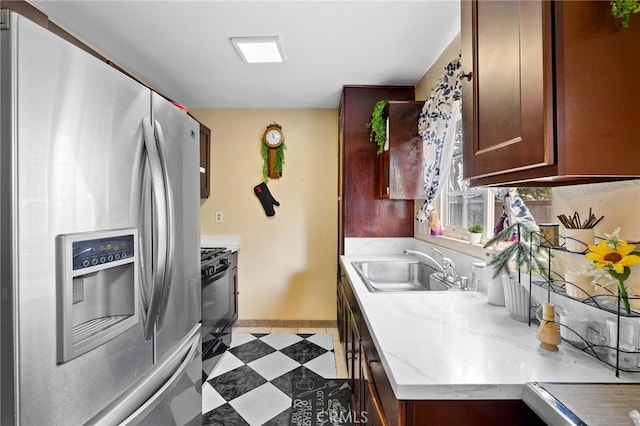 kitchen featuring stainless steel refrigerator with ice dispenser, black range, and sink