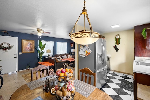 tiled dining space featuring ceiling fan and a textured ceiling