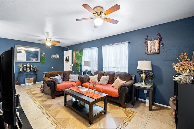 tiled living room with ceiling fan and a textured ceiling