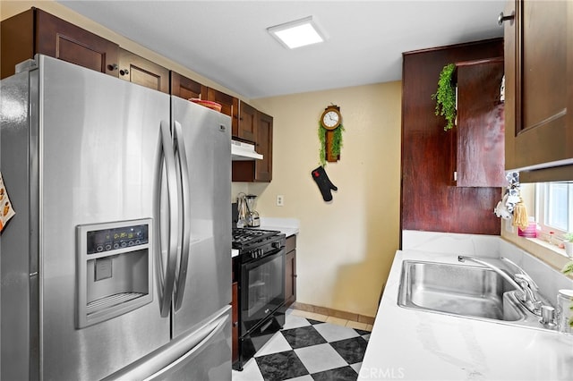 kitchen featuring black gas range, stainless steel fridge with ice dispenser, and sink