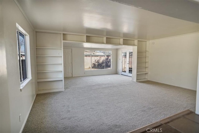 unfurnished living room featuring carpet flooring and french doors