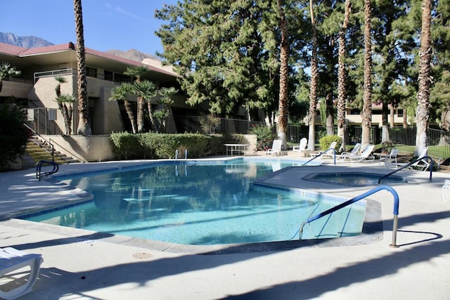 view of swimming pool with a community hot tub and a patio area