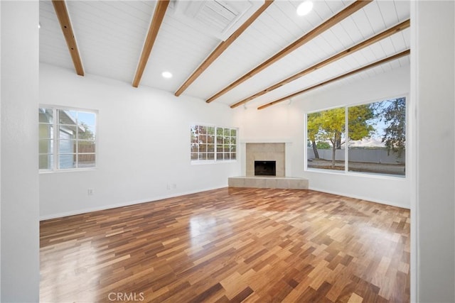 unfurnished living room featuring vaulted ceiling with beams, a fireplace, and hardwood / wood-style flooring