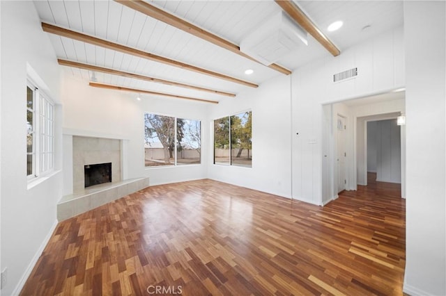 unfurnished living room featuring wood-type flooring, a fireplace, and beamed ceiling