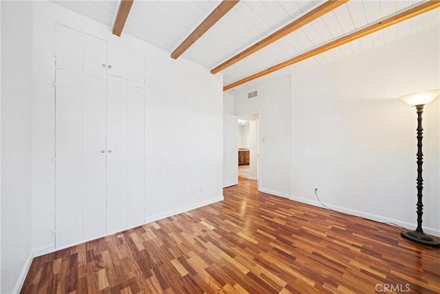 empty room featuring hardwood / wood-style floors and beam ceiling