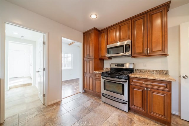 kitchen featuring stainless steel appliances and light stone countertops