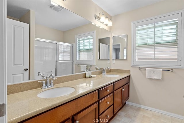 bathroom with vanity and a shower with door