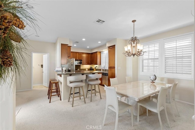 dining area with a chandelier and light carpet