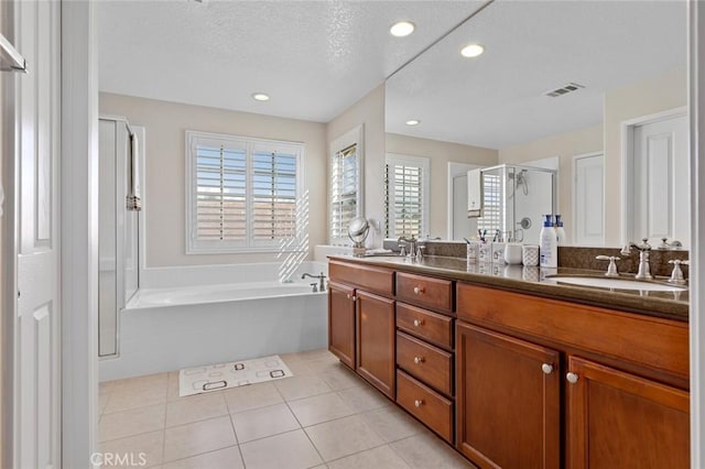 bathroom featuring vanity, tile patterned flooring, plus walk in shower, and a textured ceiling