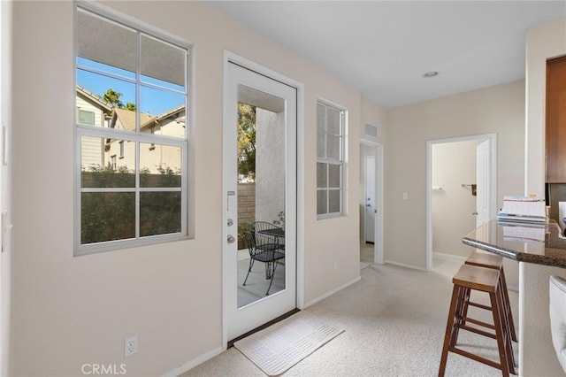 doorway featuring light carpet