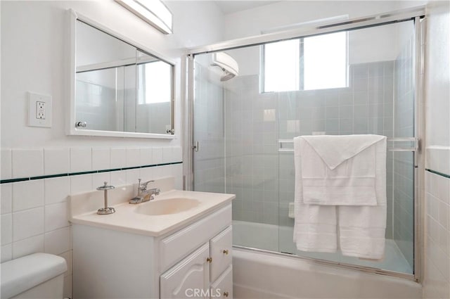 full bathroom featuring combined bath / shower with glass door, toilet, a wealth of natural light, and vanity