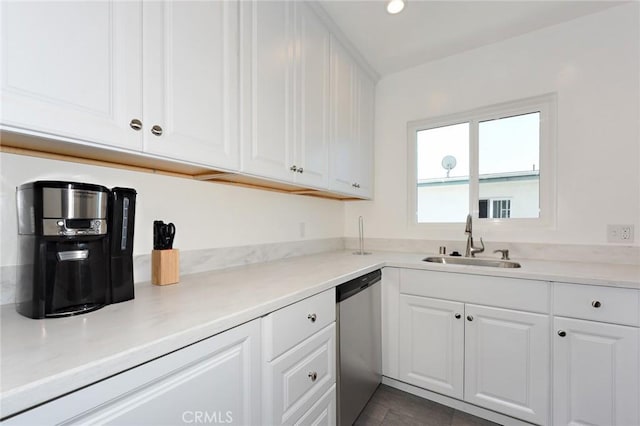 kitchen with white cabinets, dishwasher, dark tile patterned floors, and sink