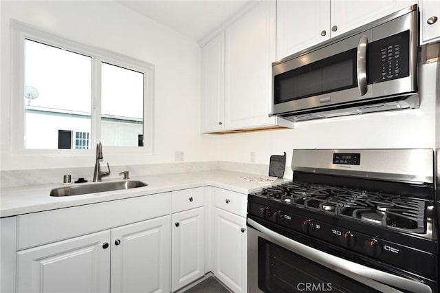 kitchen with sink, stainless steel appliances, and white cabinetry