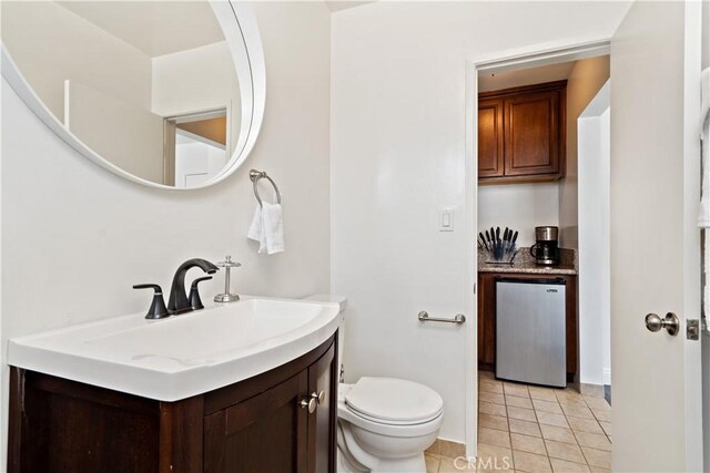 bathroom featuring tile patterned floors, vanity, and toilet