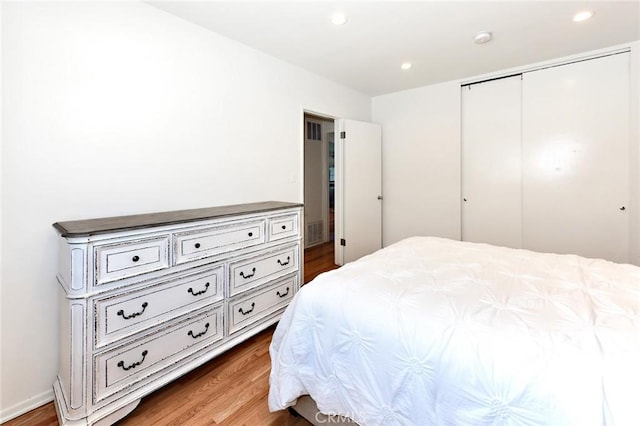 bedroom with a closet and hardwood / wood-style floors