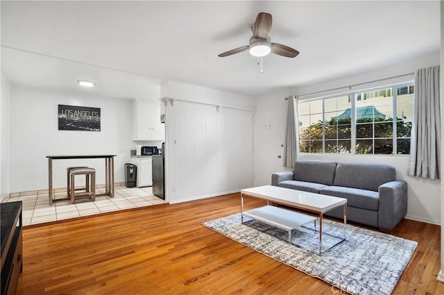 living room featuring ceiling fan and light hardwood / wood-style floors