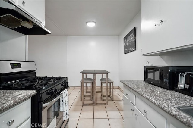 kitchen featuring light stone countertops, white cabinetry, stainless steel gas range, ventilation hood, and light tile patterned flooring