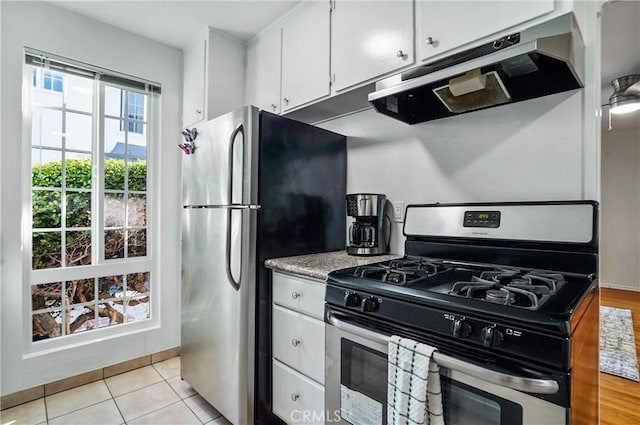 kitchen with stainless steel appliances, white cabinetry, and light tile patterned floors