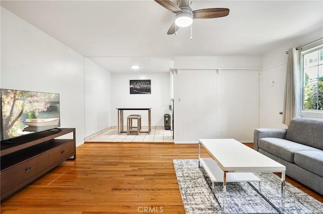 living room featuring ceiling fan and light hardwood / wood-style flooring