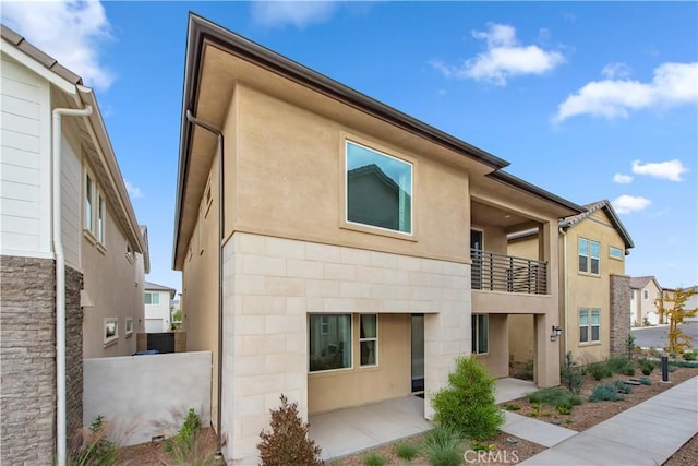 rear view of house with a balcony and a patio