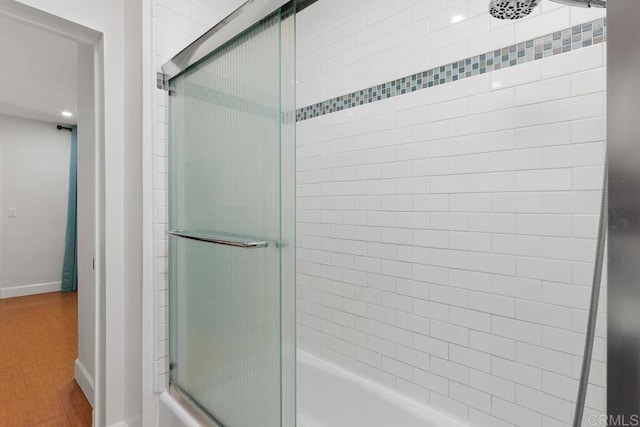 bathroom featuring hardwood / wood-style floors and shower / bath combination with glass door