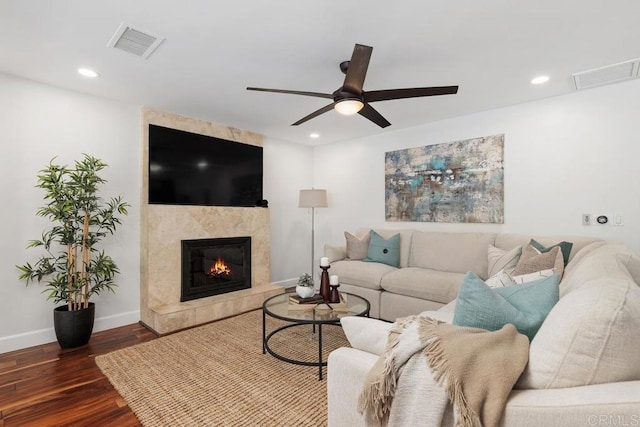 living room with ceiling fan, dark hardwood / wood-style floors, and a fireplace