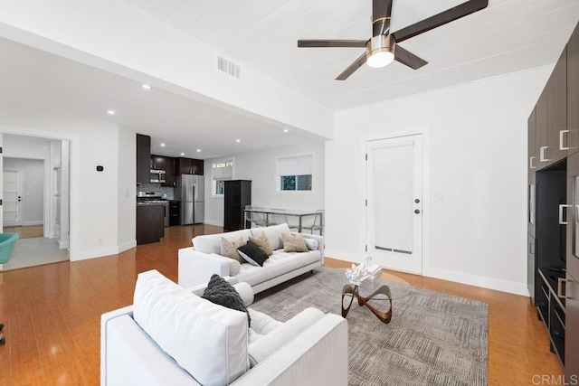 living room featuring ceiling fan and light hardwood / wood-style floors