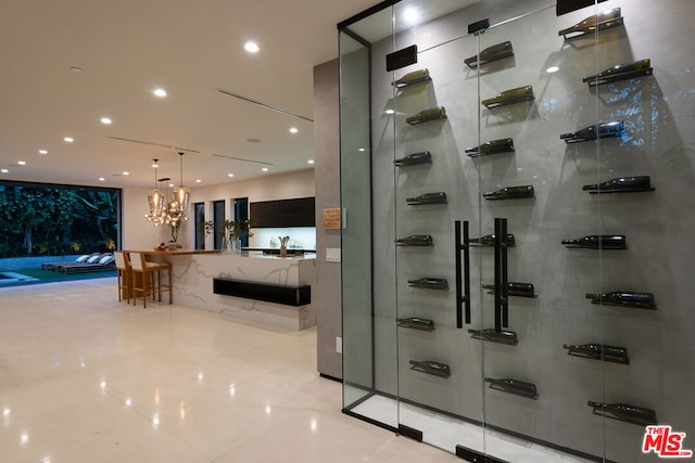 wine cellar with an inviting chandelier and light tile patterned flooring