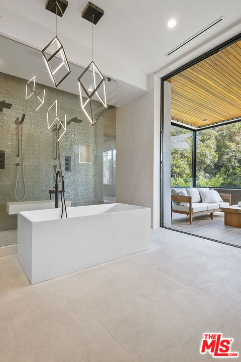 bathroom with separate shower and tub, a wall of windows, and concrete floors