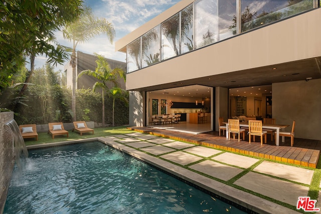 view of pool featuring pool water feature and a wooden deck