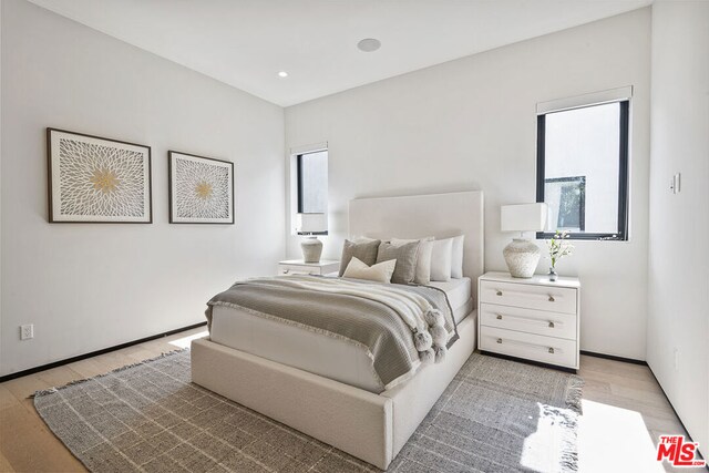 bedroom featuring light hardwood / wood-style flooring and multiple windows