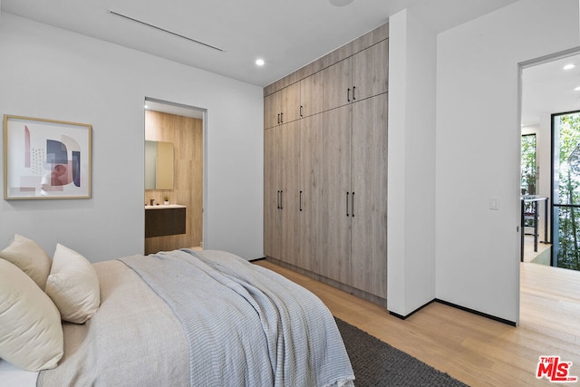 bedroom featuring light hardwood / wood-style floors and ensuite bathroom