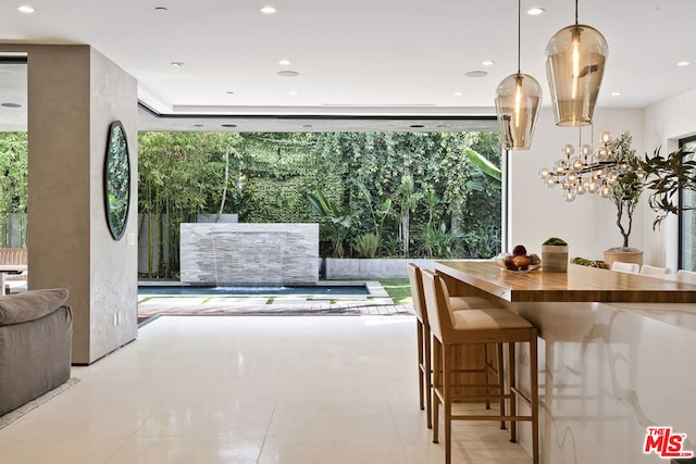 tiled dining room with a healthy amount of sunlight and a chandelier