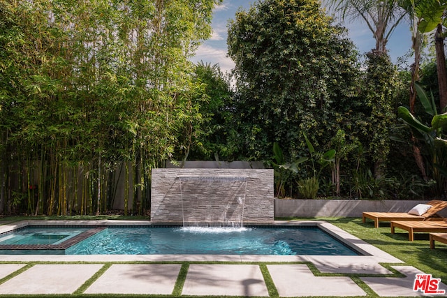 view of pool featuring pool water feature and an in ground hot tub