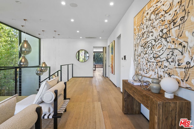 corridor with light hardwood / wood-style flooring and a wall of windows