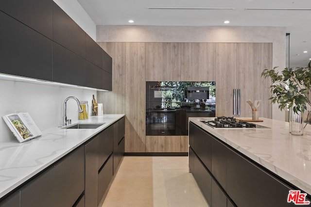 kitchen featuring light stone counters, light tile patterned floors, sink, and gas cooktop