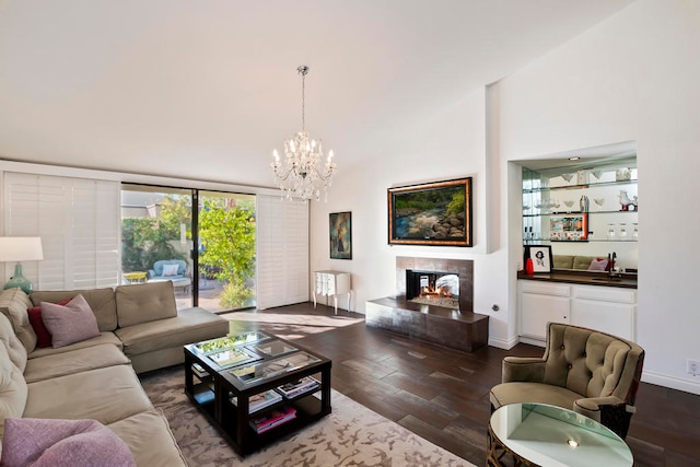 living room with a multi sided fireplace, dark hardwood / wood-style flooring, high vaulted ceiling, and an inviting chandelier