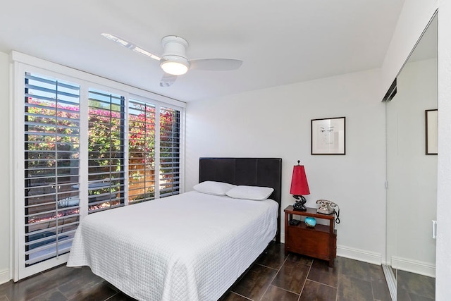 bedroom featuring ceiling fan, dark hardwood / wood-style floors, and multiple windows