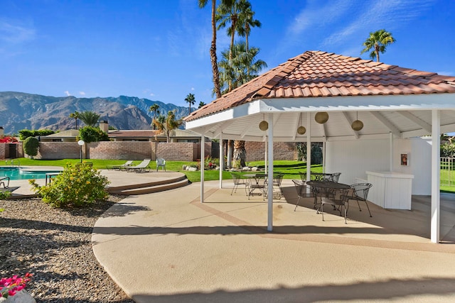 view of home's community with a mountain view, a gazebo, a patio, and a pool