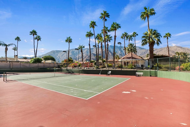 view of tennis court featuring a mountain view and basketball hoop